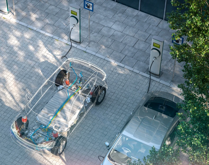 Aerial view of two electric cars parked and charging at outdoor EV charging stations surrounded by trees.