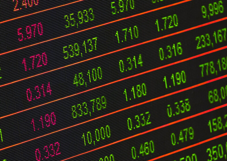 Digital stock market ticker displaying various colorful financial data and prices on a black background.