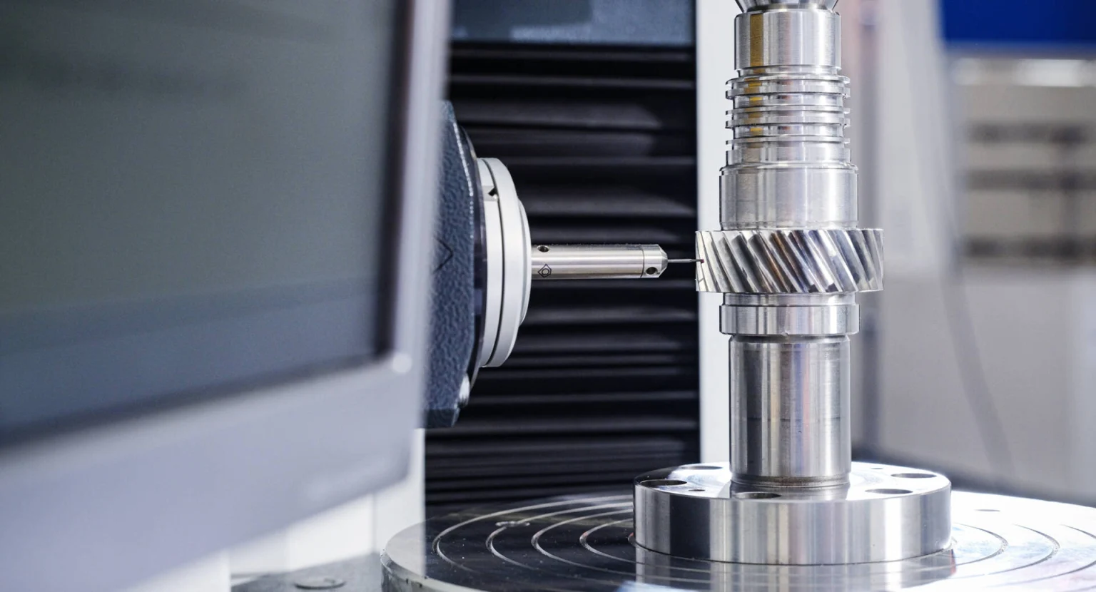 Close-up of a precision measurement device inspecting a metallic cylindrical gear component in a laboratory setting.