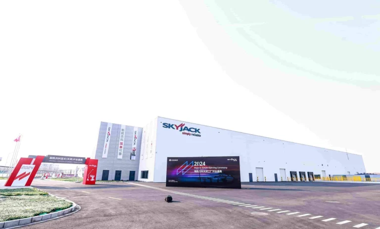 Exterior view of a large, modern SkyVacs industrial building with clear signage and a wide surrounding road.