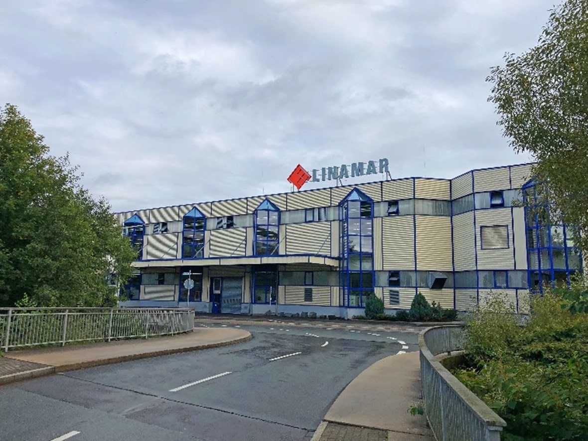Exterior view of the Lindner Hotel building with blue and beige facade under a cloudy sky.