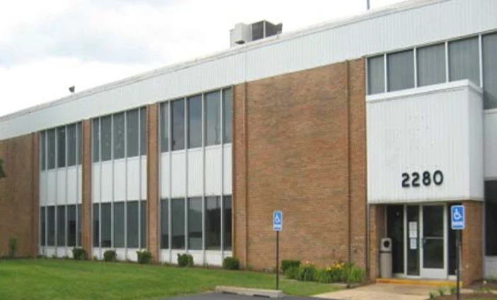 Two-story brick and glass office building with the number 2280 displayed near the entrance, alongside accessible parking signs.