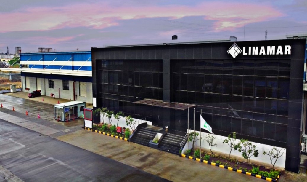 Exterior view of the Linamar industrial facility with clear signage under a colorful evening sky.