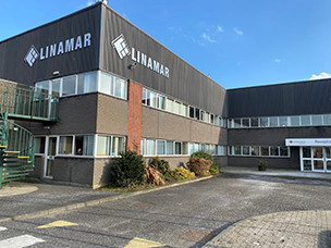 Exterior view of the Linamar industrial building under a clear blue sky, showing the company logo on the facade.