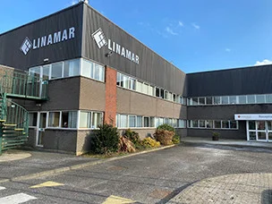 Exterior view of the Linamar industrial building under a clear blue sky, showing the company logo on the facade.