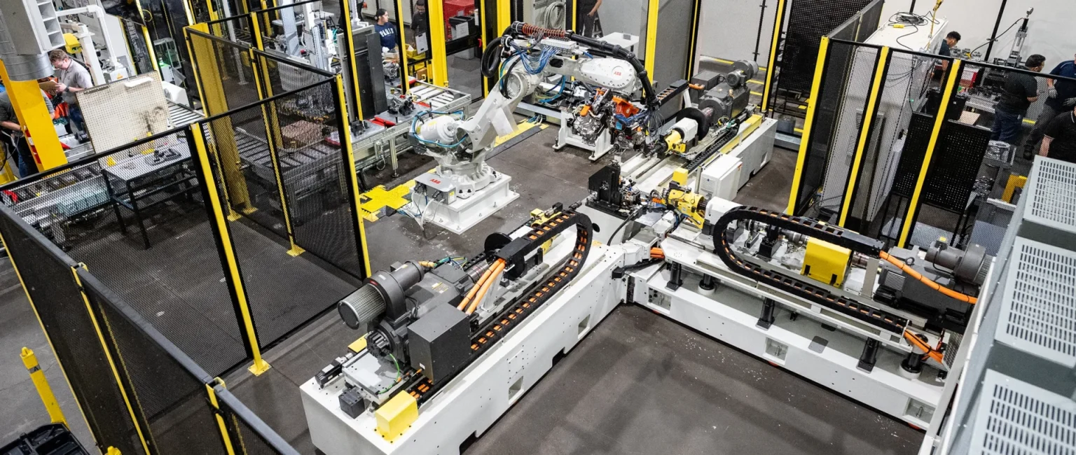 Industrial robotic arms operating on an automated manufacturing assembly line in a modern factory.